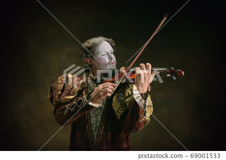 Young man as Johann Sebastian Bach on dark green background. Retro style, comparison of eras concept. 69001533