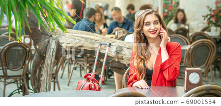 Young woman is talking on cell phone. 69001534
