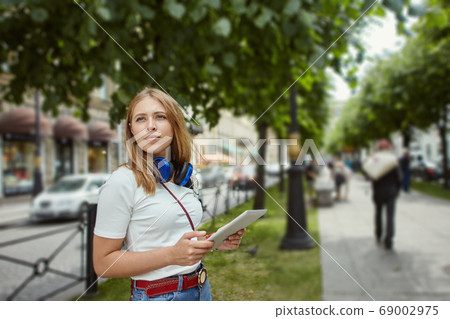 Young woman walks with tablet PC. 69002975