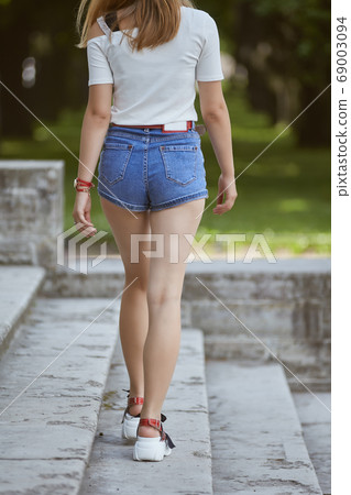 White woman walks in garden pavilion. White woman walks in garden pavilion. 69003094