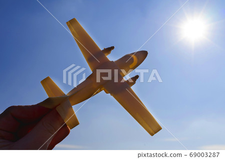 close up photo of male hand holding toy airplane 69003287
