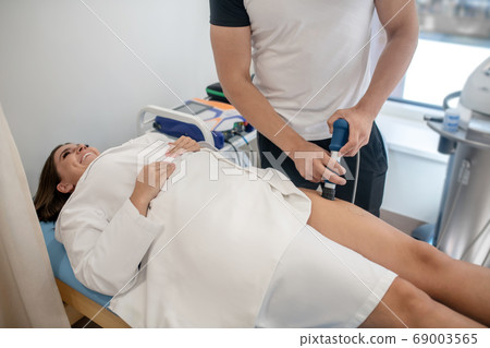 Doctor examining a woman with a specific apparatus Doctor examining a woman with a specific apparatus 69003565