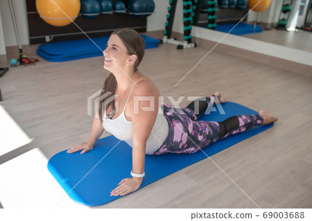 Woman stretching her back muscles during the training 69003688