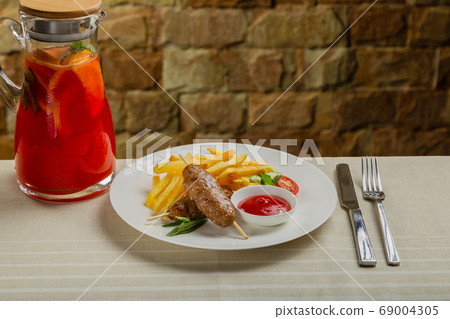Freshly fried kebab with fried potatoes and tomato 69004305