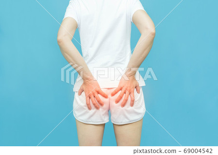 woman in white clothes put her hand on the bottom area, painful illness feeling unwell ,Hemorrhoids concept on white background 69004542