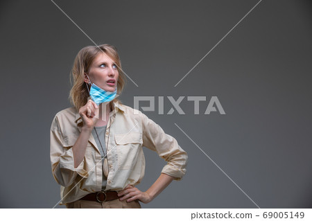 Blond woman take off her surgical mask Blond woman take off her surgical mask 69005149