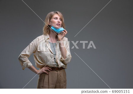 Blond woman take off her surgical mask Blond woman take off her surgical mask 69005151