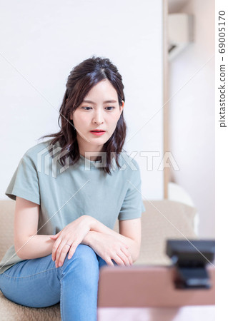 Woman receiving online medical treatment with a personal computer 69005170