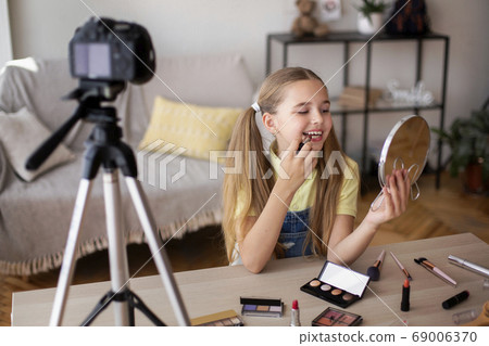 Smiling Girl Applying Makeup, Recording Her Beauty Blog Smiling Girl Applying Makeup, Recording Her Beauty Blog 69006370