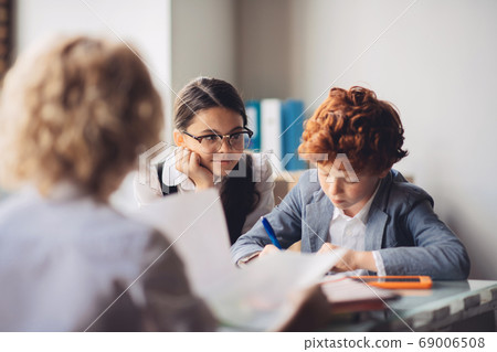 Three kids studying together and looking busy Three kids studying together and looking busy 69006508