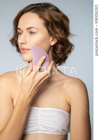 Lovely serene female doing a cosmetic procedure Lovely serene female doing a cosmetic procedure 69008265