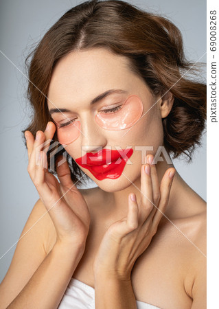 Calm lady using the lip and under-eye masks Calm lady using the lip and under-eye masks 69008268