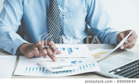 Businessman analysis the chart with laptop at the office for setting challenging business goals Businessman analysis the chart with laptop at the office for setting challenging business goals 69008649