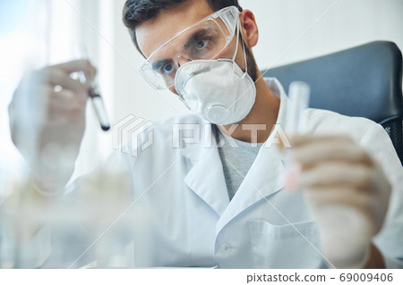 Biochemist examining biological substances in a laboratory 69009406