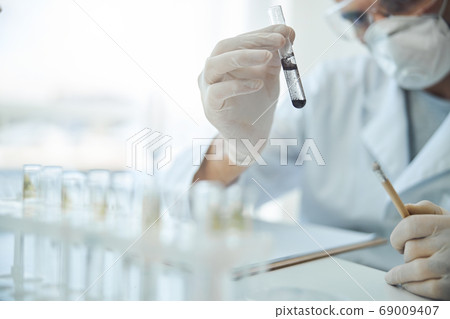 Virologist performing a chemical test in a lab 69009407