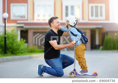 Little boy with scooter says goodbye and hugging 69009736