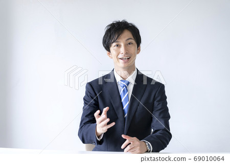 Young men in suits talking from the camera 69010064