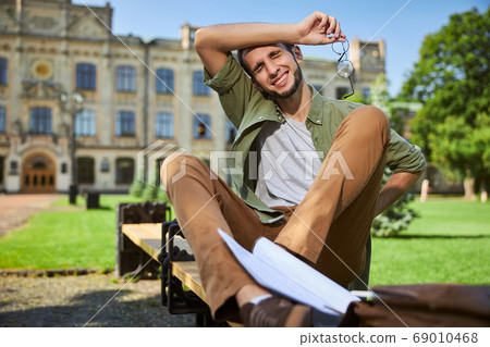 Tired male student experiencing a severe backache Tired male student experiencing a severe backache 69010468
