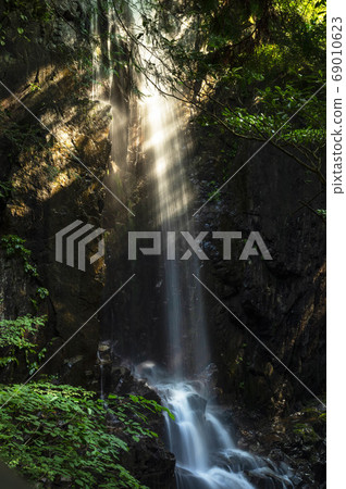 Valley waterfall illuminated by the morning sun 69010623