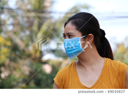 Masked Asian woman prevent germs. Tiny Particle or virus corona or Covid 19 protection. Masked Asian woman prevent germs. Tiny Particle or virus corona or Covid 19 protection. 69010837
