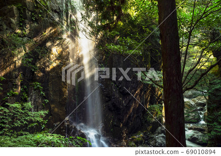 Valley waterfall illuminated by the morning sun 69010894