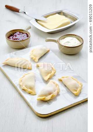 Cherry vareniki on marble serving board with 69011209