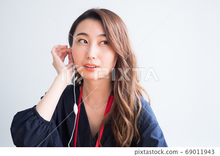 Woman listening to the sound of earphones Woman listening to the sound of earphones 69011943