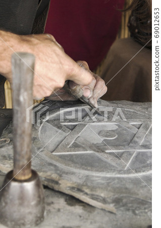 man working stone and tools 69012653