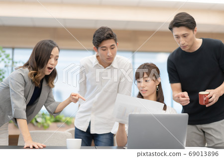 A female employee who operates a computer while checking data and male bosses who talk and give advice on that side A female employee who operates a computer while checking data and male bosses who talk and give advice on that side 69013896