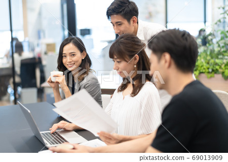 A female employee who operates a computer while checking data and male bosses who talk and give advice on that side A female employee who operates a computer while checking data and male bosses who talk and give advice on that side 69013909