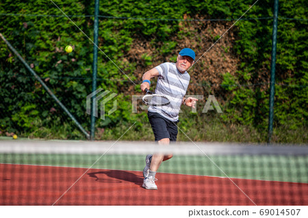 Active senior man playing the tennis outdoor, pensioner sport concept, healthy lifestyle senior 69014507