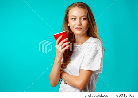 Young attractive woman holding a cup of hot drink 69015405