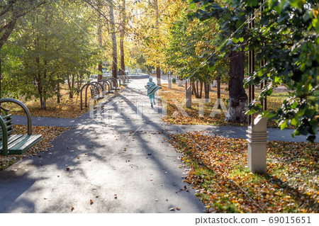 Girl is running in autumn park, yellow leaves 69015651