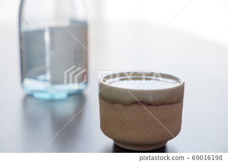 Sake and bottle poured in the mouth 69016198