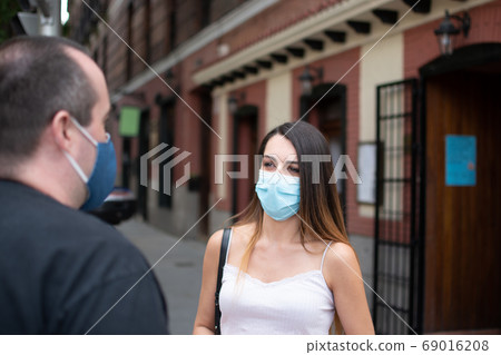 戴著口罩的外國婦女避免交談和交談 戴著口罩的外國婦女避免交談和交談 69016208