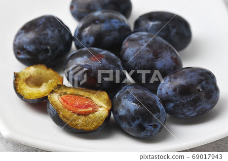 juicy ripe black and blue plums on a plate juicy ripe black and blue plums on a plate 69017943