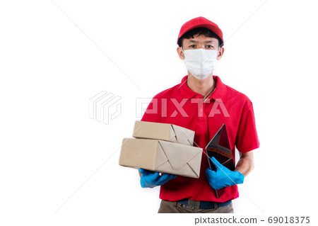 Delivery man in medical safety mask holding and Delivery man in medical safety mask holding and 69018375