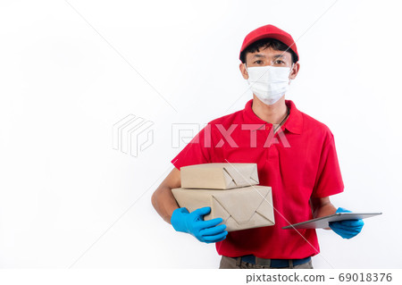 Delivery man in medical safety mask holding and Delivery man in medical safety mask holding and 69018376