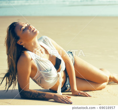 young pretty blond woman at seacoast walking relaxing, fashion lady at sunset, lifestyle people vacations concept 69018957