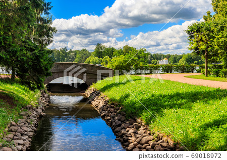 Stone arch bridge across a small river Stone arch bridge across a small river 69018972