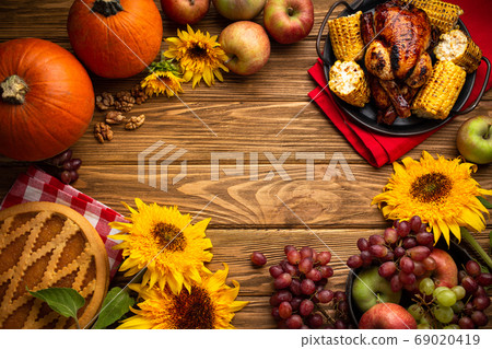 Thanksgiving festive table composition with roasted turkey, pumpkin pie, autumn fruit. Thanksgiving celebration dinner with traditional fall meals on rustic wooden table. Space for text, from above. Thanksgiving festive table composition with roasted turkey, pumpkin pie, autumn fruit. Thanksgiving celebration dinner with traditional fall meals on rustic wooden table. Space for text, from above. 69020419