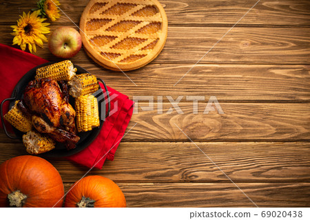 Thanksgiving festive table composition with roasted turkey, pumpkin pie, autumn fruit. Thanksgiving celebration dinner with traditional fall meals on rustic wooden table. Space for text, from above. Thanksgiving festive table composition with roasted turkey, pumpkin pie, autumn fruit. Thanksgiving celebration dinner with traditional fall meals on rustic wooden table. Space for text, from above. 69020438