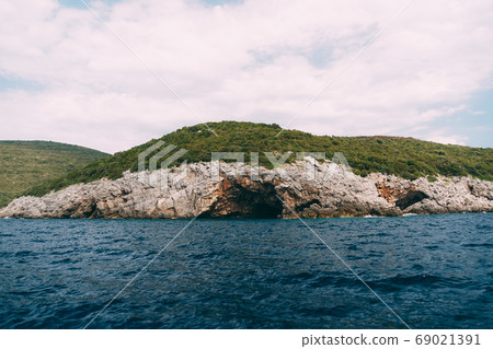 A cave in a rock on the Lustica Peninsula, in Montenegro. A cave in a rock on the Lustica Peninsula, in Montenegro. 69021391