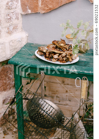Toasted lamb ribs on a white plate. 69021532