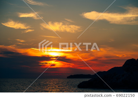 Fiery red sunset sky over the sea. Fiery red sunset sky over the sea. 69022150