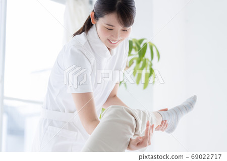 Medical physiotherapist and senior woman rehabilitating the foot 69022717