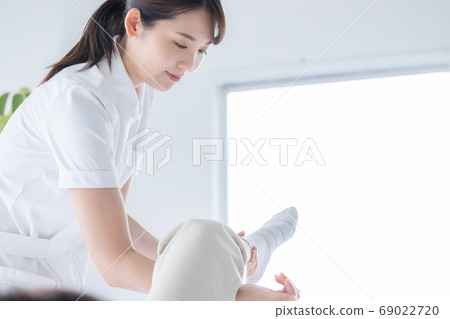 Medical physiotherapist and senior woman rehabilitating the foot Medical physiotherapist and senior woman rehabilitating the foot 69022720