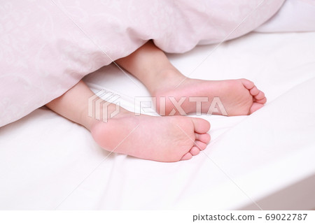 赤腳的一個女孩在床上睡覺 69022787