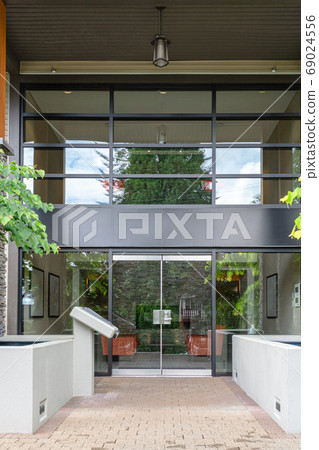 Entrance of new residential building with paved area in front 69024556