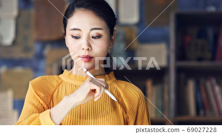 Woman using a pen tablet in a dark room 69027228